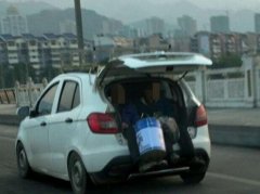 2名老人坐进行驶的轿车后备箱 市民看着后背发凉