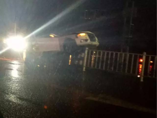 小车骑上公路隔离带 车头都翘起来了