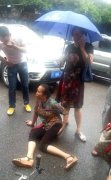 老太骑自行车撞上轿车 女司机下车为其撑伞