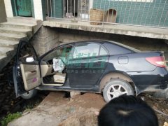 重庆一辆轿车栽进民房墙外 引路人围观