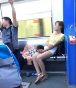 女子带小孩坐轻轨躺卧座椅  周围乘客站着