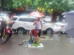 重庆街头老人冒雨卖菜 城管温暖撑伞获赞