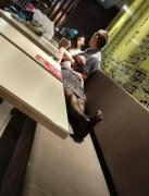 大妈餐厅座椅当床睡  还有大叔当靠枕