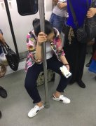 女子地铁上把行李箱当座椅   淡定玩手机