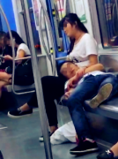 男子车厢里躺着睡觉  邻座女子用腿为其当枕头