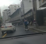 男子车流中脚踩“风火轮”头上骑小孩 过往车主很愤怒