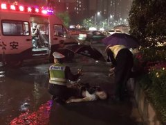 两男子饮酒过量醉倒路边  交警雨中为其撑伞