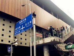 男子坐在铁杆顶  路人：怎么上去的？