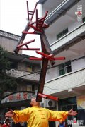 这个杂耍艺人厉害 牙齿轻松顶起50斤板凳