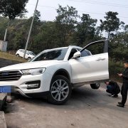 轿车卡在坡坎上后轮悬空  进退两难