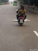 摩托司机驾车不戴头盔   还横放较长物品
