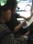 “学霸美女”公交车上做作业 同行同学靠在肩上看小说