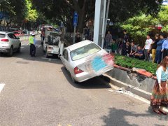 私家车转弯处“骑上”花坛   姿势有点尴尬