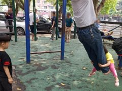男子手握吊栏健身   两小孩缠其腿上“荡秋千”
