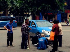 骑摩托的外卖小哥与小车相撞  瘫坐在地