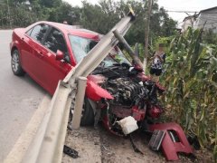 轿车驶出公路冲断栏杆   车头严重被毁