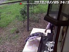 大妈从居民楼前经过  顺手拿走他人雨伞和衣服