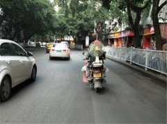 男子骑摩托载着风扇    边行驶边吹风