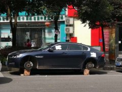 轿车停路边  三个轮胎变成了“砖块”